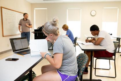 Students making notes in a classroom with Dr. Ledford