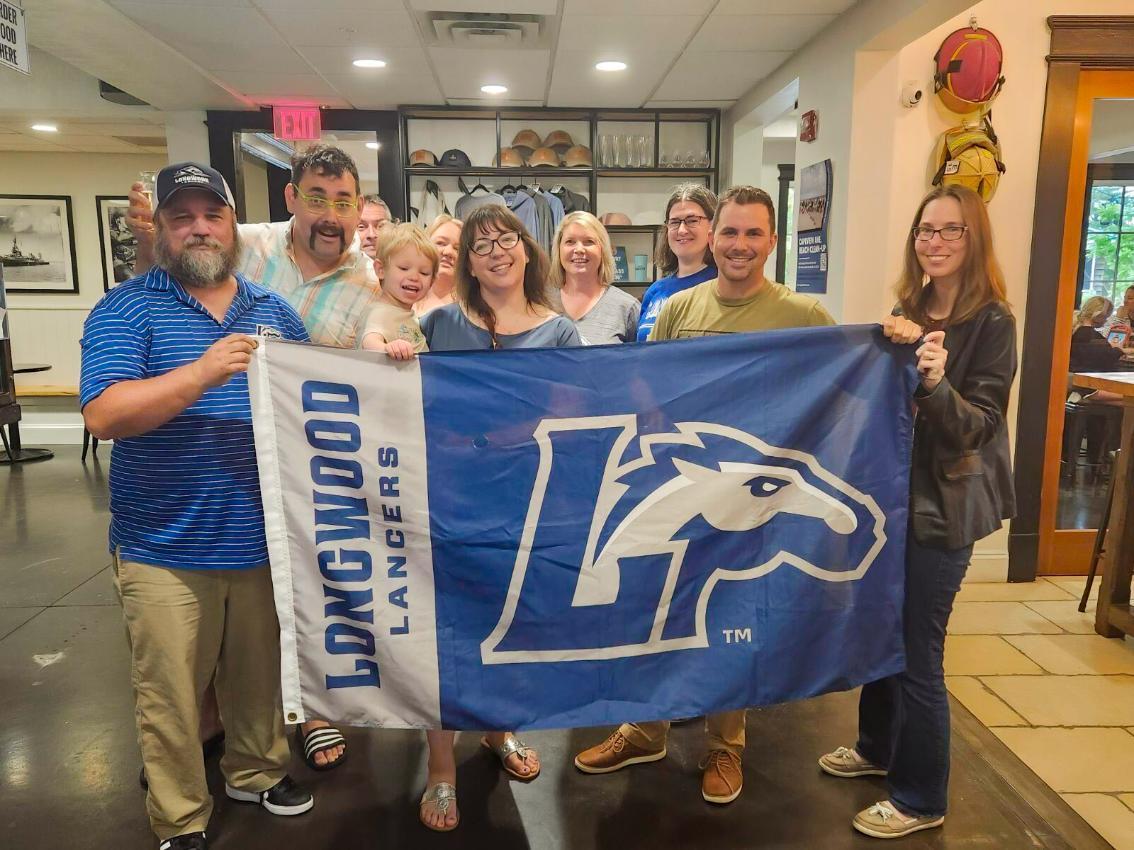 RVA Alums gather around a Longwood flag