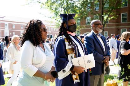 student at commencement with family 