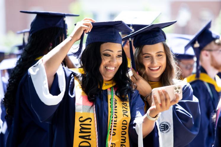 two students smile and take a selfie