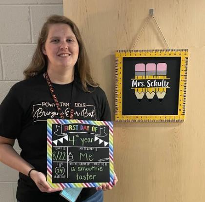 Erin Shultz holds a first day of school sign