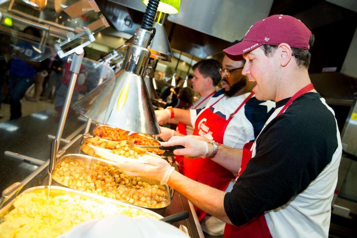  Faculty and staff serve food to students during Late Night Breakfast