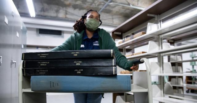 Staff member helps unload the archives from the Farmville Herald