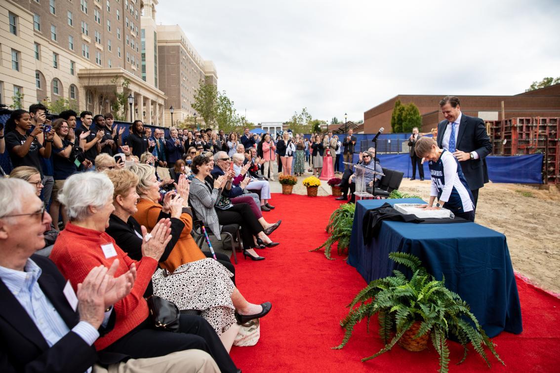 Joan Perry Brock '64 places her hands into wet cement to officially mark the construction of the game-changing convocation center that will soon bear her name